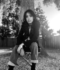 a black and white photo of a woman sitting on a chair